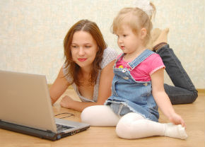 mom looking at laptop with child